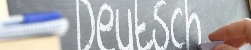 Grammatik und Sprachbetrachtung: Deutsch jemand schreibt auf eine Tafel das Wort "Deutsch"