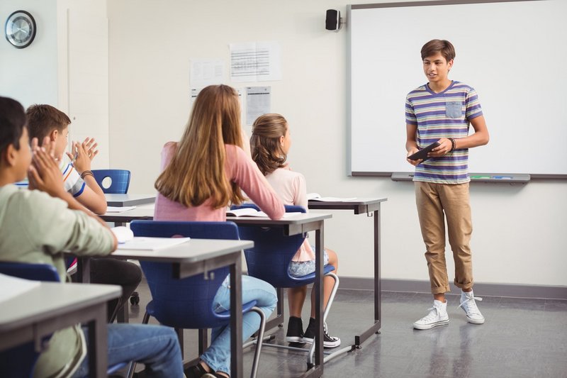 Schüler steht vor der Klasse und hält ein Referat.