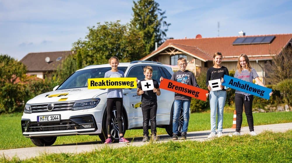 Achtung Auto, Bildungsprogramm der ADAC Stiftung Kinder vor einem Auto; sie üben die Formel Reaktionsweg + Bremsweg = Anhalteweg