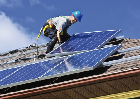 Arbeiter auf Dach mit Photovoltaikanlage